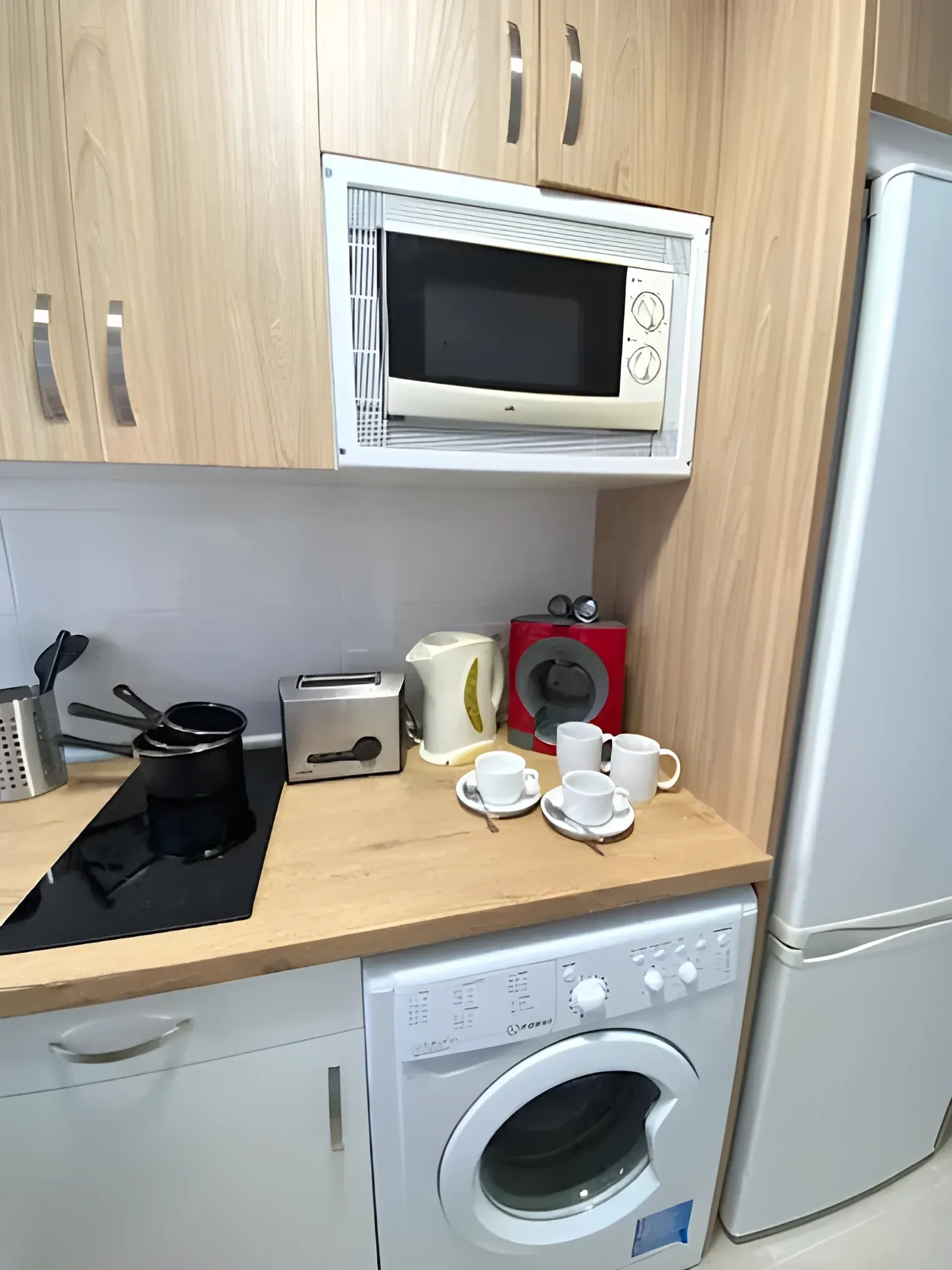Cocina equipada con lavadora, microondas y nevera