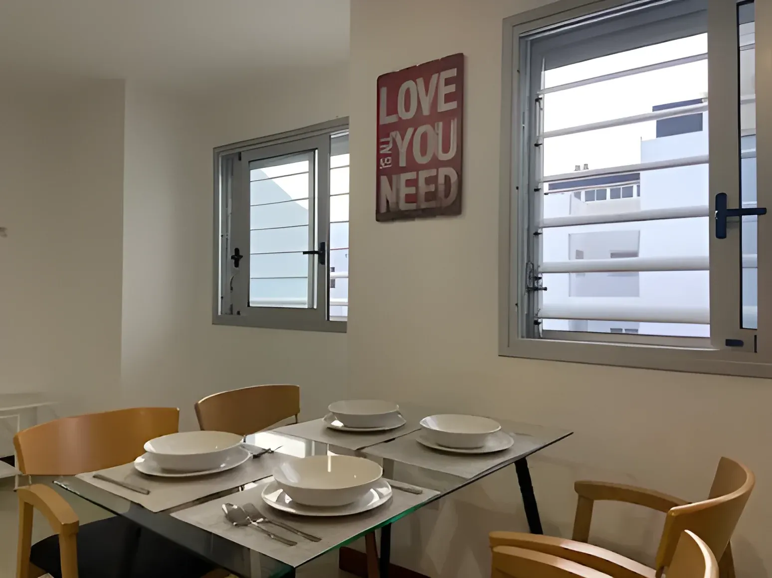 Mesa de comedor preparada junto a la ventana